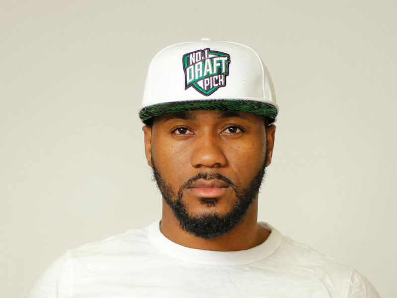 Unisex white cap with embroidered Boston lettering, curved brim, and adjustable strap, combining clean design with city-inspired streetwear flair